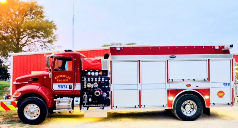 A firetruck from the kitchener fire department parked outside, featuring a vibrant red and white color scheme, detailed control panel, and department insignia.